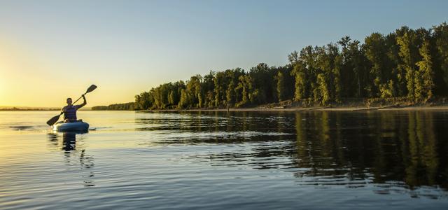 person kayaking on a calm lake